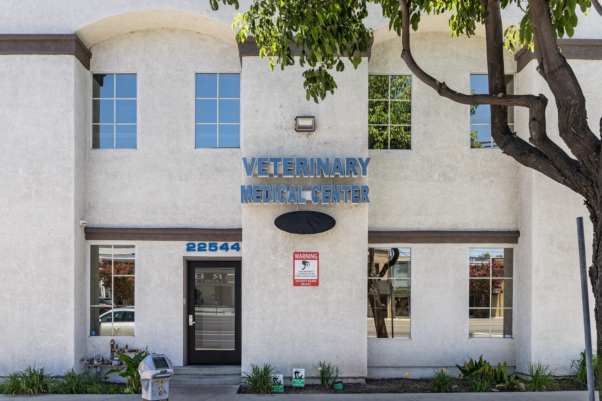 Exterior of Veterinary Medical Center of Woodland Hills building with blue signage and tree